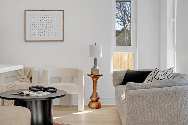 living area featuring light wood-type flooring and baseboards