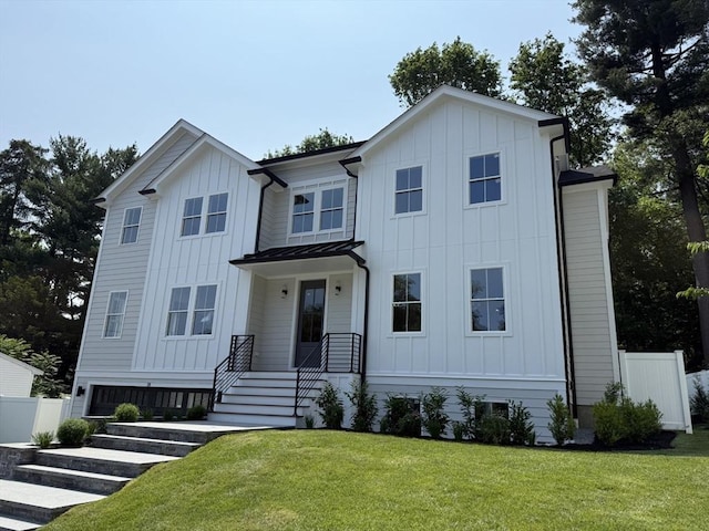 22 Irene Cir, Waltham, MA 02453 - view of front facade with board and batten siding, a standing seam roof, and a metal roof
