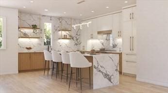 22 Irene Cir, Waltham, MA 02453 - kitchen featuring a breakfast bar area, light wood-style floors, recessed lighting, and light countertops