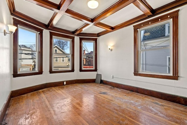 spare room with coffered ceiling, baseboards, hardwood / wood-style flooring, and a healthy amount of sunlight