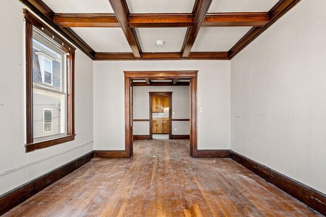 spare room with coffered ceiling, baseboards, beamed ceiling, and hardwood / wood-style floors