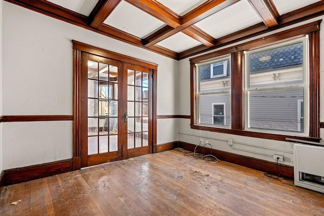 empty room featuring hardwood / wood-style flooring, baseboards, heating unit, french doors, and coffered ceiling