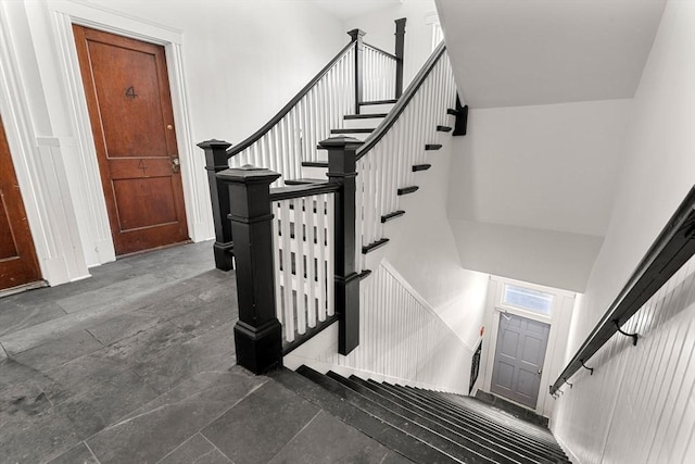 stairway featuring a towering ceiling