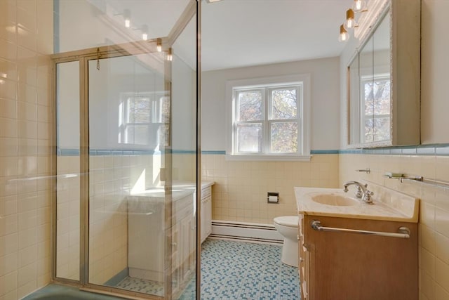 full bath featuring a baseboard radiator, a shower stall, tile walls, and vanity