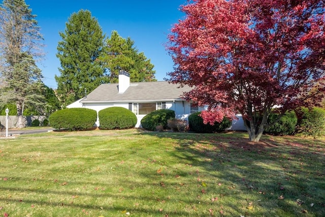 view of front of home with a chimney and a front yard