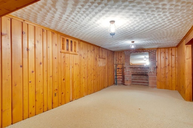 finished basement with carpet floors, ornamental molding, and wooden walls