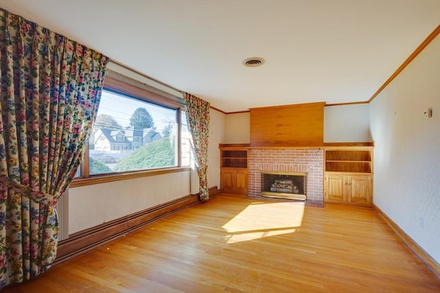 unfurnished living room with a brick fireplace, baseboards, ornamental molding, and wood finished floors