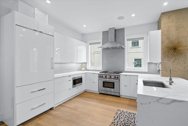 26 Salisbury Rd Unit 26, Newton, MA 02458 - kitchen featuring wall chimney range hood, designer stove, modern cabinets, a sink, and recessed lighting