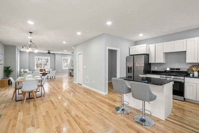 kitchen with a center island, stainless steel appliances, pendant lighting, a breakfast bar area, and light wood-type flooring