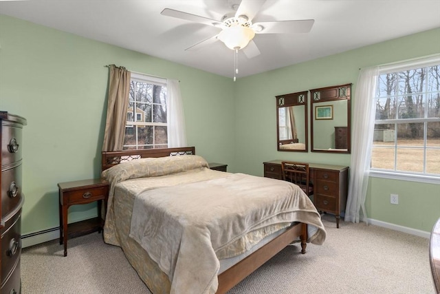 bedroom with a baseboard heating unit, carpet floors, baseboards, and a ceiling fan