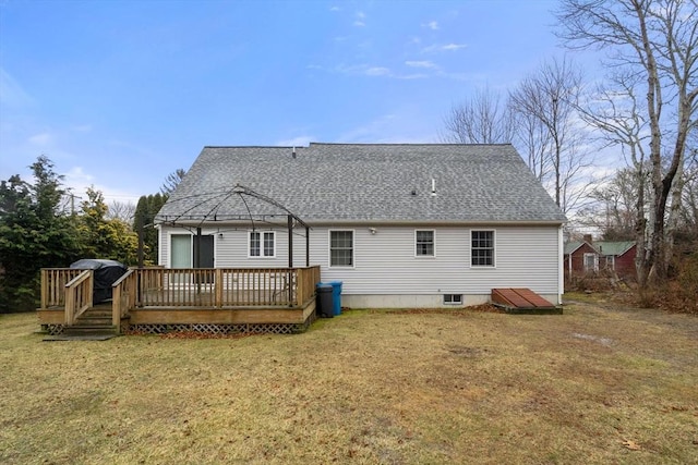 rear view of property with a shingled roof, a yard, and a wooden deck