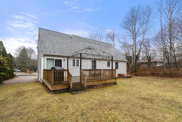 rear view of property featuring a gazebo, a shingled roof, a lawn, and a wooden deck