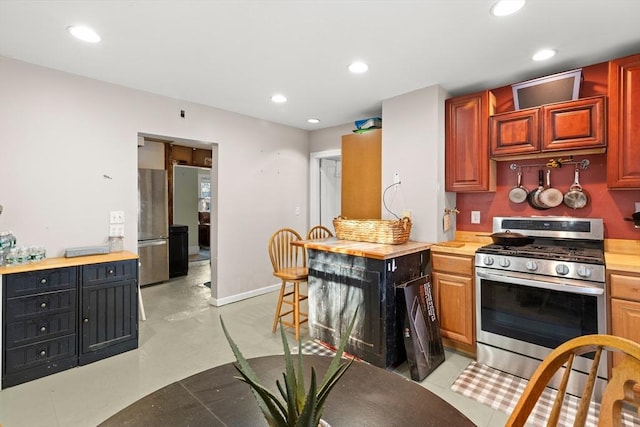 kitchen with baseboards, appliances with stainless steel finishes, butcher block counters, and recessed lighting