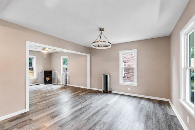 26 Olivine St, Chicopee, MA 01013 - unfurnished living room with radiator, wood finished floors, and a wood stove