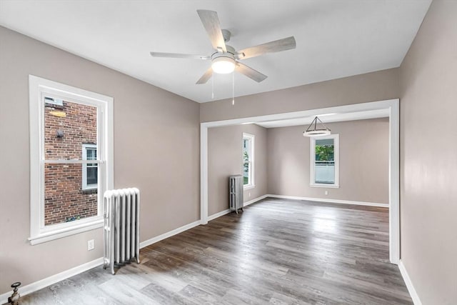 26 Olivine St, Chicopee, MA 01013 - empty room with radiator, wood finished floors, and a ceiling fan