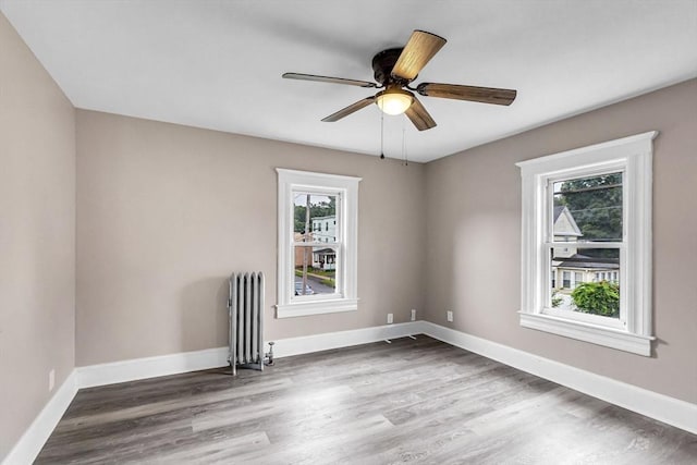 26 Olivine St, Chicopee, MA 01013 - empty room featuring radiator heating unit, wood finished floors, and ceiling fan