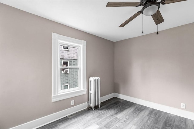 26 Olivine St, Chicopee, MA 01013 - empty room featuring radiator heating unit, a ceiling fan, and wood finished floors