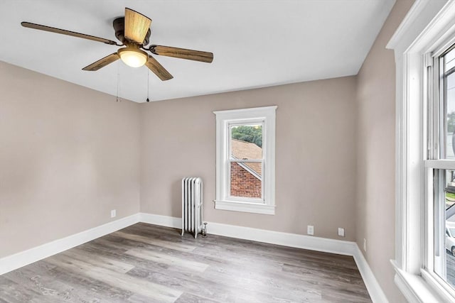 26 Olivine St, Chicopee, MA 01013 - spare room featuring radiator heating unit, wood finished floors, and a ceiling fan