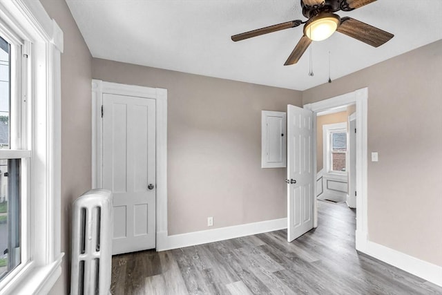26 Olivine St, Chicopee, MA 01013 - unfurnished bedroom with radiator, light wood-style floors, and ceiling fan