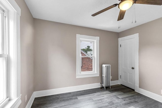26 Olivine St, Chicopee, MA 01013 - empty room featuring radiator heating unit, ceiling fan, and wood finished floors