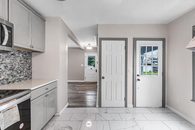 26 Olivine St, Chicopee, MA 01013 - kitchen with stainless steel microwave, gray cabinets, light marble finish flooring, and plenty of natural light