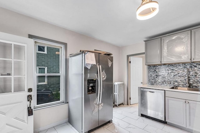 26 Olivine St, Chicopee, MA 01013 - kitchen featuring stainless steel appliances, radiator, gray cabinets, backsplash, and light countertops