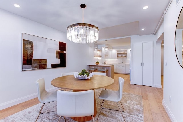 dining room featuring an inviting chandelier and light wood-type flooring