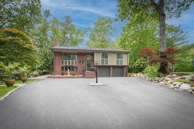 597 Fisher Rd, Dartmouth, MA 02747 - split foyer home featuring driveway, a chimney, an attached garage, and brick siding