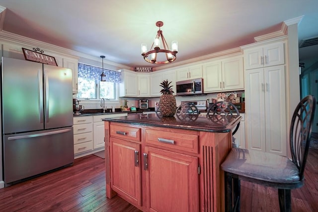 597 Fisher Rd, Dartmouth, MA 02747 - kitchen with stainless steel appliances, a chandelier, crown molding, dark wood finished floors, and a center island