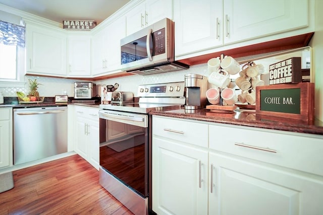 597 Fisher Rd, Dartmouth, MA 02747 - kitchen with appliances with stainless steel finishes, white cabinetry, light wood-type flooring, and dark stone counters