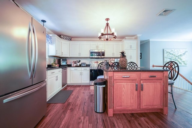 597 Fisher Rd, Dartmouth, MA 02747 - kitchen with appliances with stainless steel finishes, dark countertops, a chandelier, dark wood finished floors, and crown molding