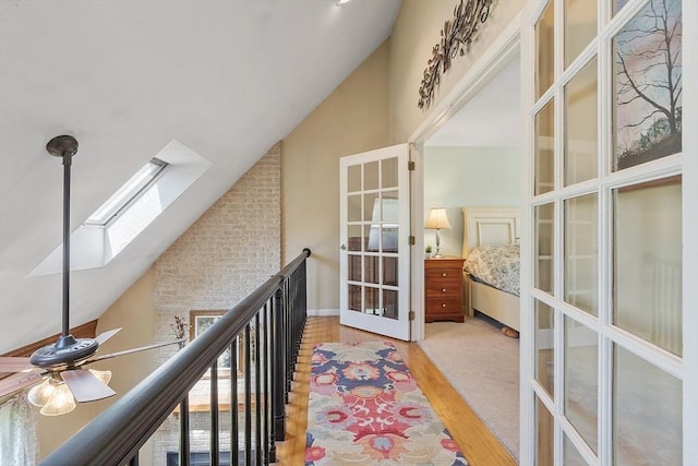 3 Sycamore Dr, Rutland, MA 01543 - hallway featuring french doors, high vaulted ceiling, a skylight, wood finished floors, and plenty of natural light