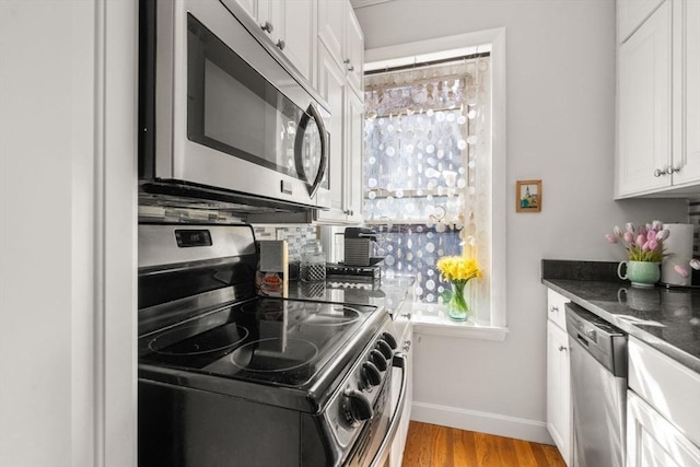 15 University Unit 32, Brookline, MA 02445 - kitchen featuring stainless steel appliances, white cabinets, and dark countertops