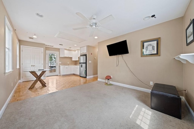 unfurnished living room featuring ceiling fan, baseboards, attic access, recessed lighting, and light carpet