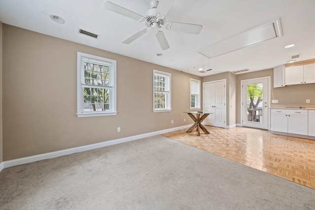 unfurnished living room featuring recessed lighting, attic access, baseboards, visible vents, and a ceiling fan