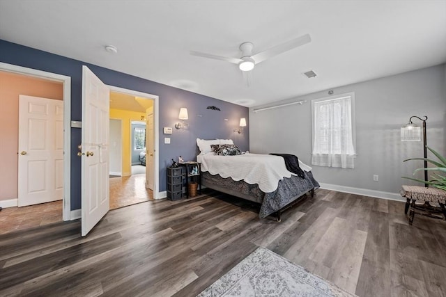 bedroom featuring wood finished floors, visible vents, and multiple windows