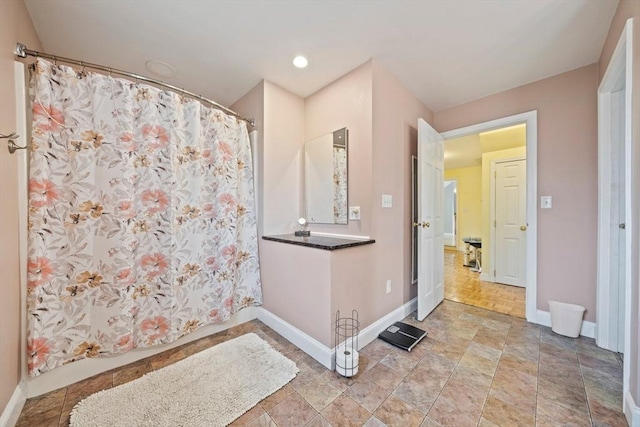full bath with curtained shower, stone finish flooring, recessed lighting, and baseboards