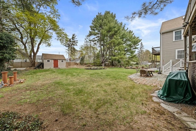 view of yard with an outdoor structure, a storage shed, a fenced backyard, and a patio area