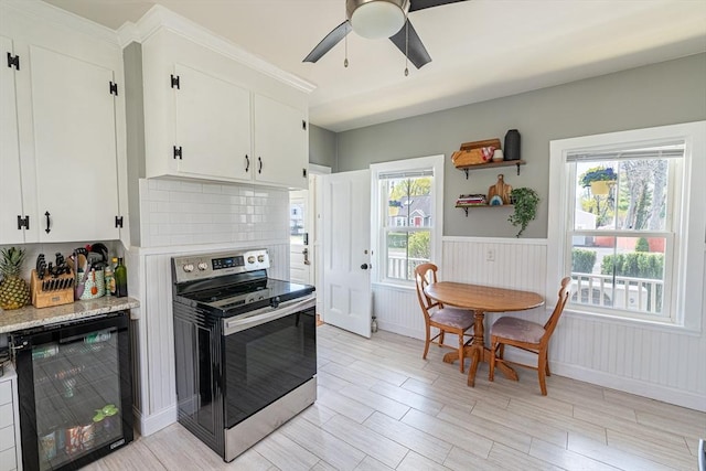 kitchen with tasteful backsplash, light wood-style flooring, beverage cooler, stainless steel electric stove, and ceiling fan