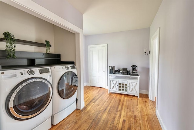laundry room with baseboards, light wood-type flooring, laundry area, and independent washer and dryer