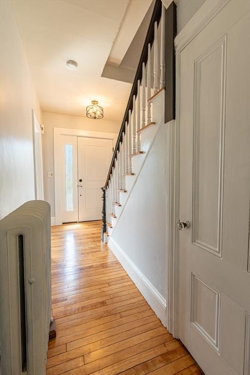 foyer with baseboards, stairway, and light wood-style floors