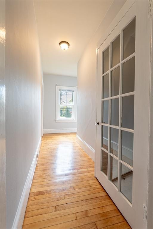 hallway featuring baseboards and light wood-type flooring