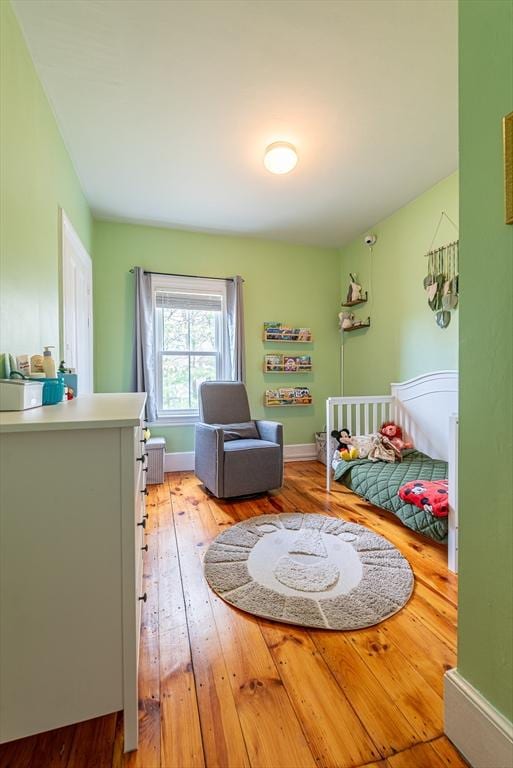 bedroom featuring light wood finished floors and baseboards