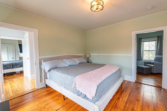 bedroom with hardwood / wood-style floors and ornamental molding