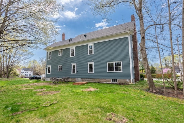 back of property with a lawn and a chimney