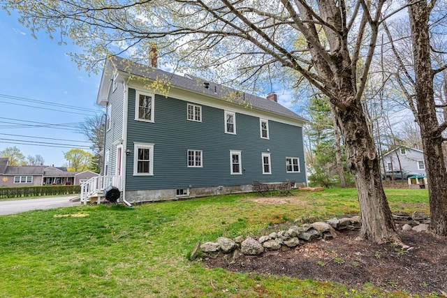 view of home's exterior with a lawn and a chimney