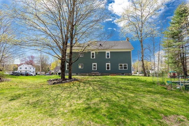 view of side of property featuring a lawn and a chimney