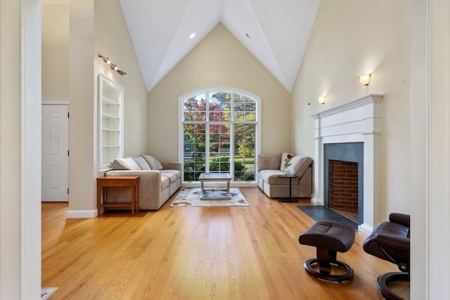 living room with high vaulted ceiling and light wood-type flooring