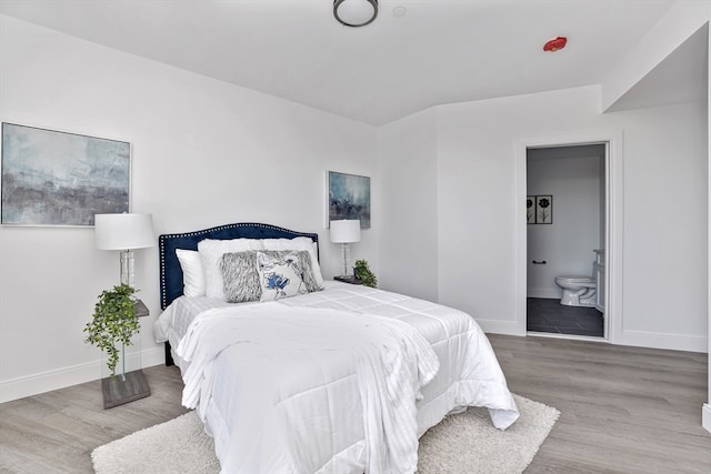 bedroom featuring connected bathroom and hardwood / wood-style floors