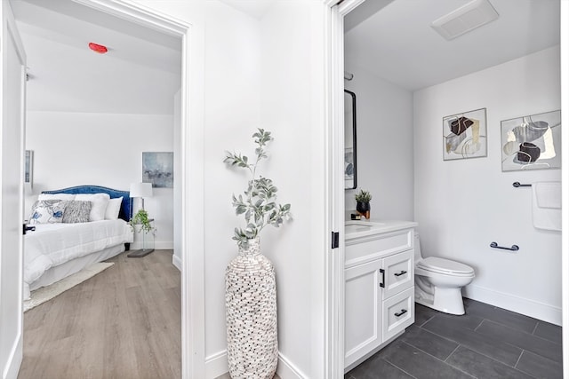 bathroom with hardwood / wood-style flooring, vanity, and toilet